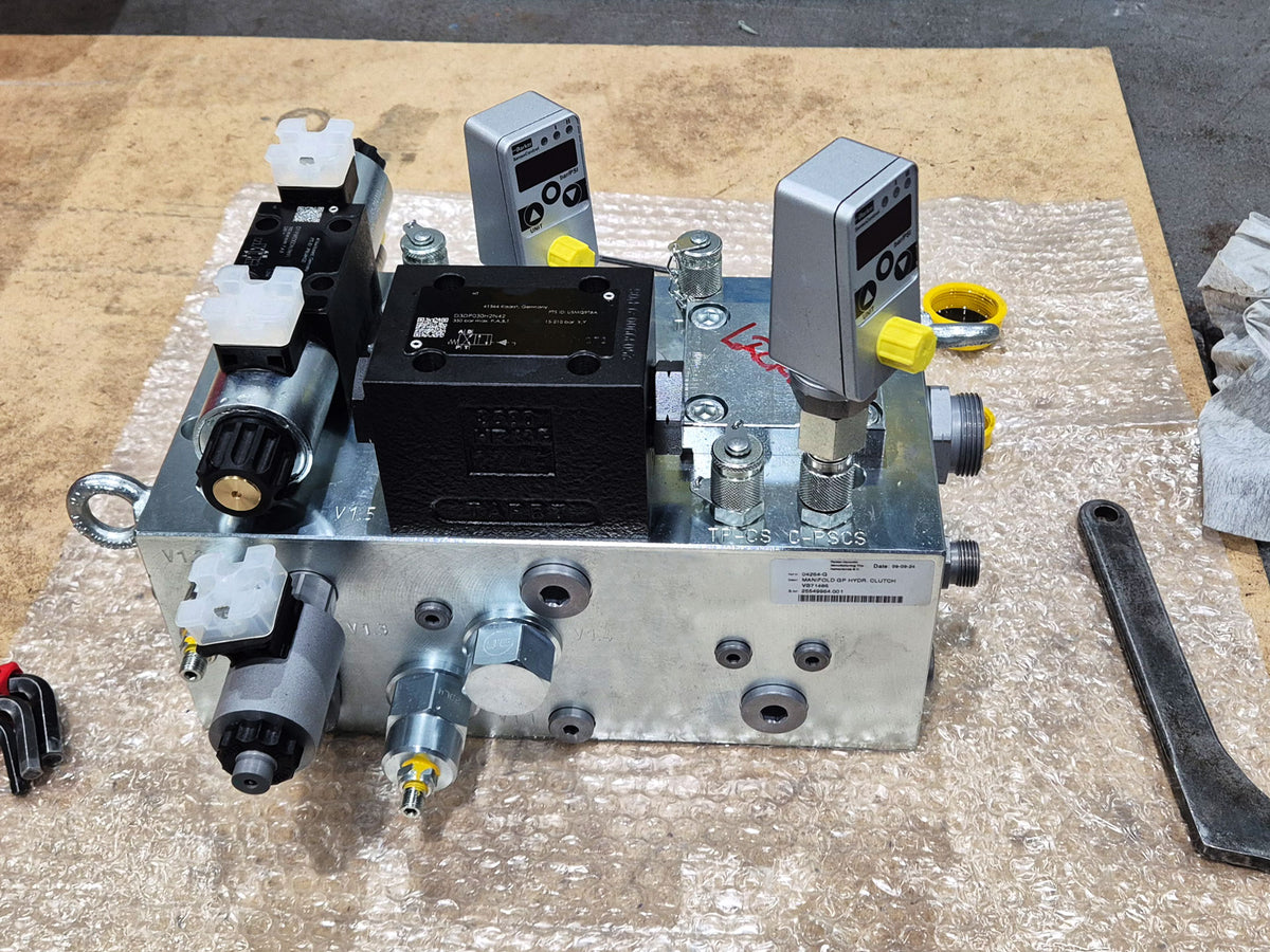 V14 manifold hydraulic valve block with mounted solenoid valve, pressure sensors, and fittings, packaged in bubble wrap with a manufacturer nameplate