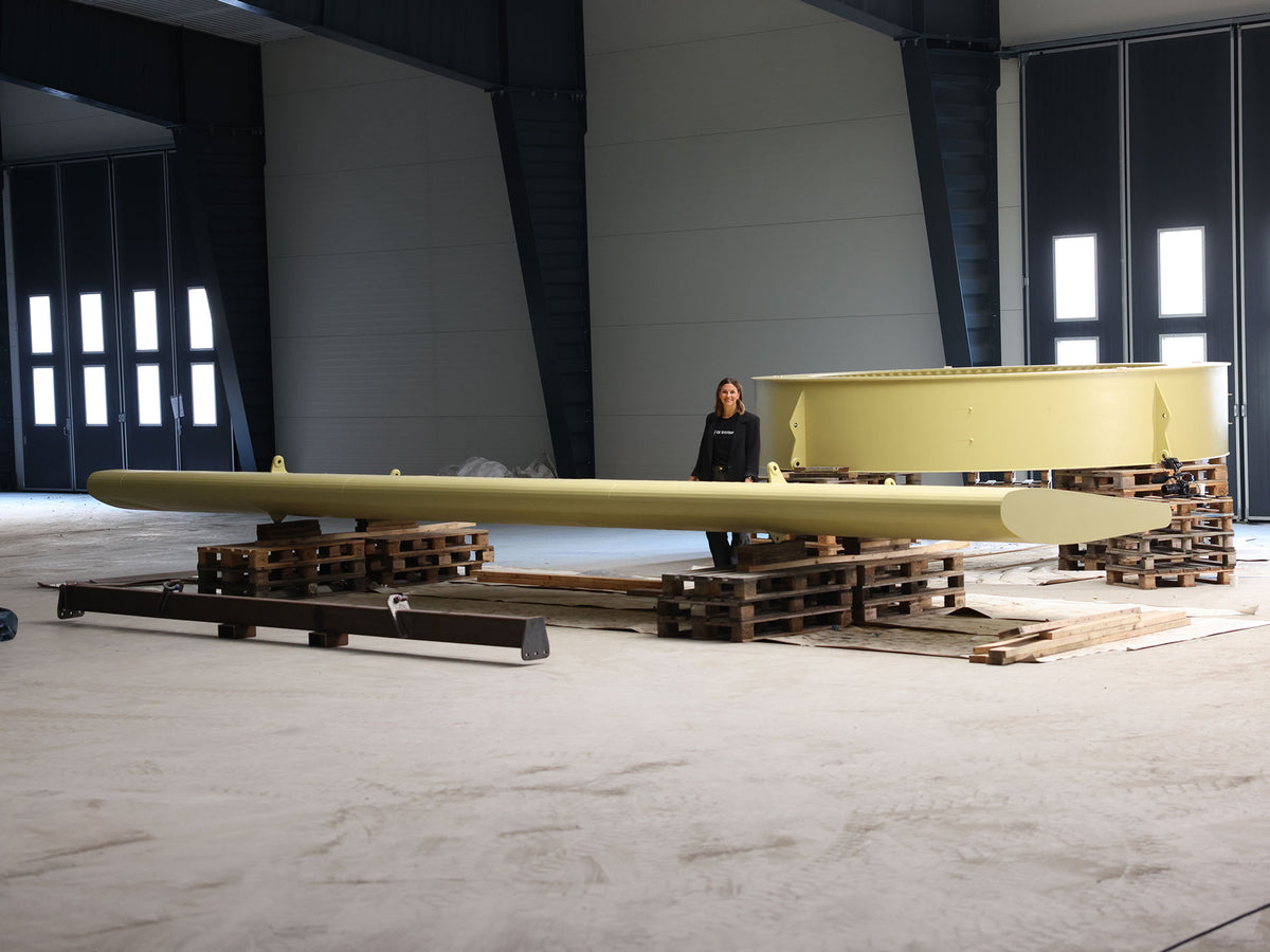 Large-scale OE Systems WaveMove wave energy converter components, including hull and buoy structures, in a warehouse before installation.