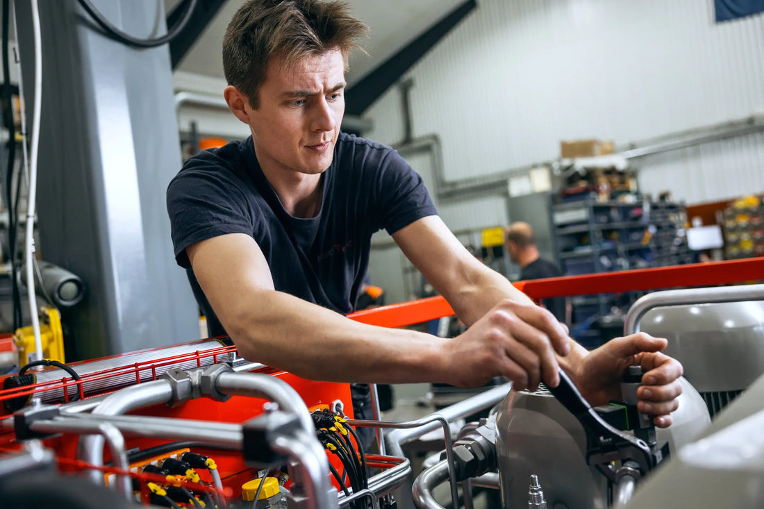 HydTec technician using a wrench on hydraulic equipment in a workshop